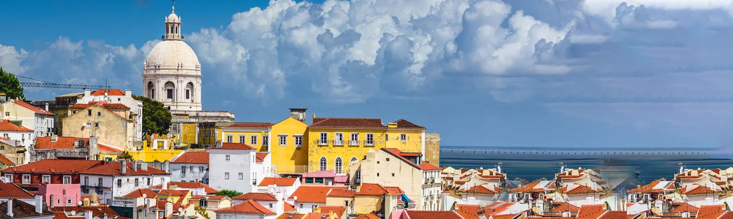 Historic architecture of Lisbon featuring colorful buildings and a cathedral under blue skies.