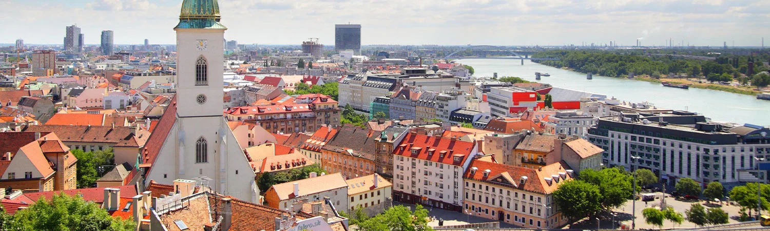 A panoramic view of the picturesque cityscape of Bratislava, showcasing the iconic architecture, serene river, and vibrant urban life.