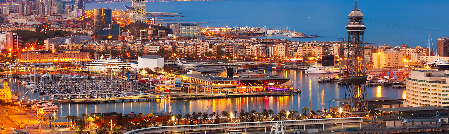 A panoramic view of Barcelona’s vibrant nightlife, modern architecture, and scenic waterfront under the evening sky.