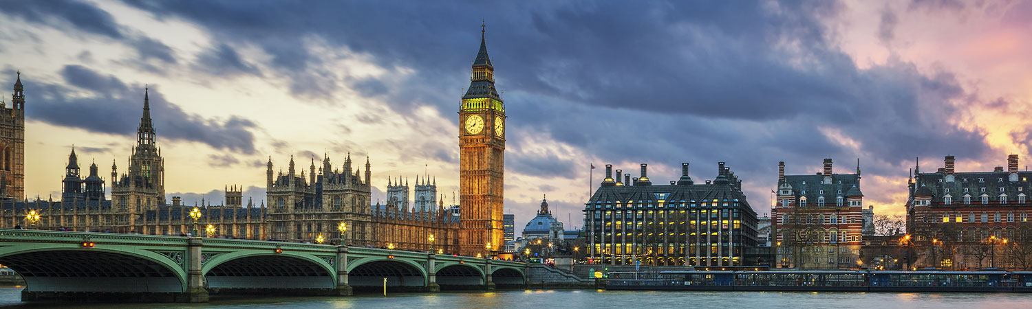 A panoramic view of the iconic Big Ben, the Houses of Parliament, and the Westminster Bridge at sunset, showcasing London’s historic architecture and scenic beauty.