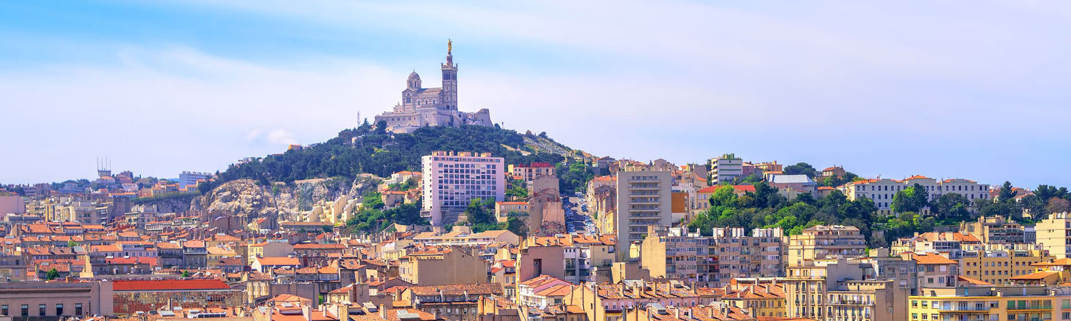 The image presents a panoramic view of Marseille, showcasing the iconic Notre-Dame de la Garde basilica perched on a hill.