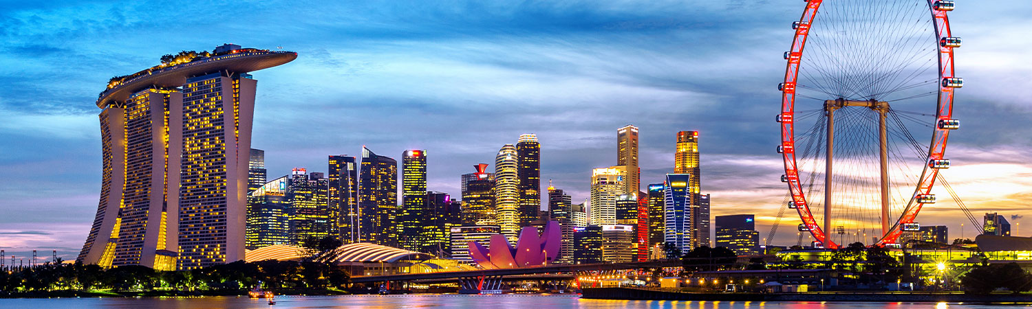 Panoramic view of Singapore skyline at dusk with Marina Bay Sands and Singapore Flyer