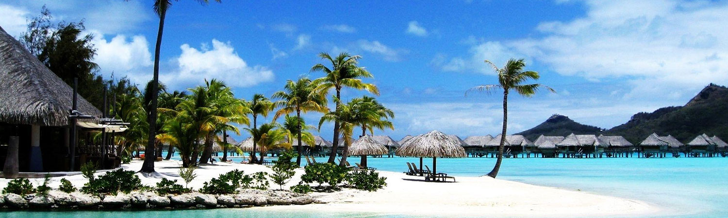 Breathtaking view of a tropical paradise with crystal clear waters, pristine white sandy beaches, and luxurious overwater bungalows nestled among swaying palm trees in Bora Bora.
