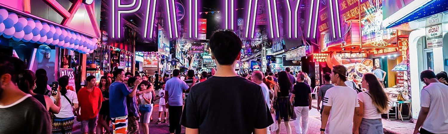 A bustling night scene at Pattaya's walking street, filled with people, vibrant neon lights, and various entertainment venues.