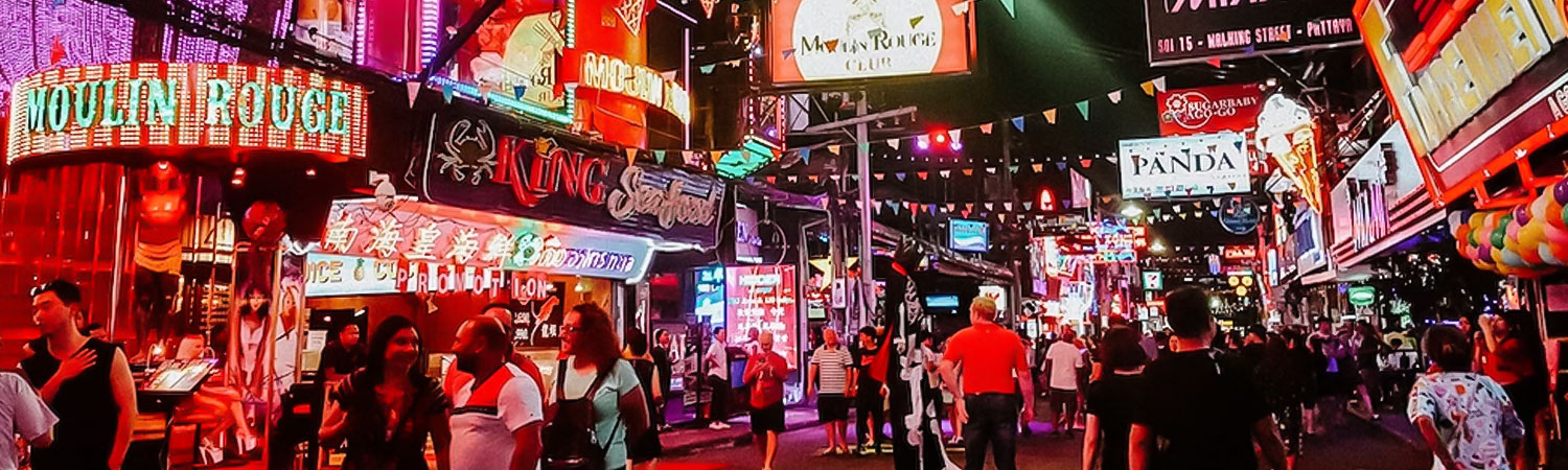 A bustling nightlife scene at a busy street filled with neon signs, including 