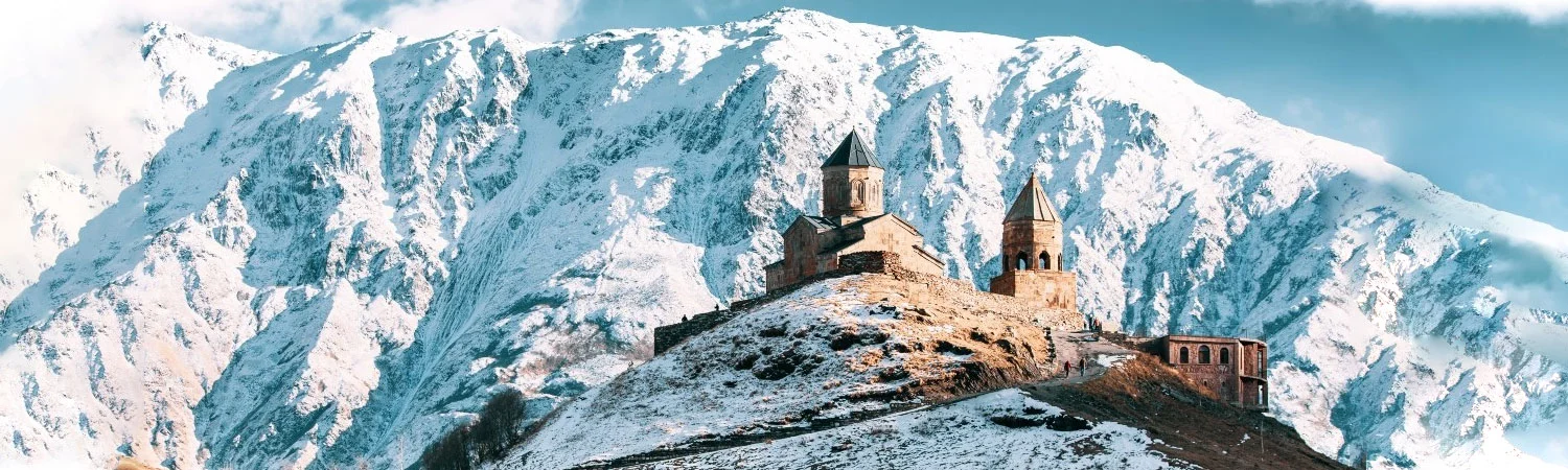 An ancient stone castle on a snowy mountain peak in georgia