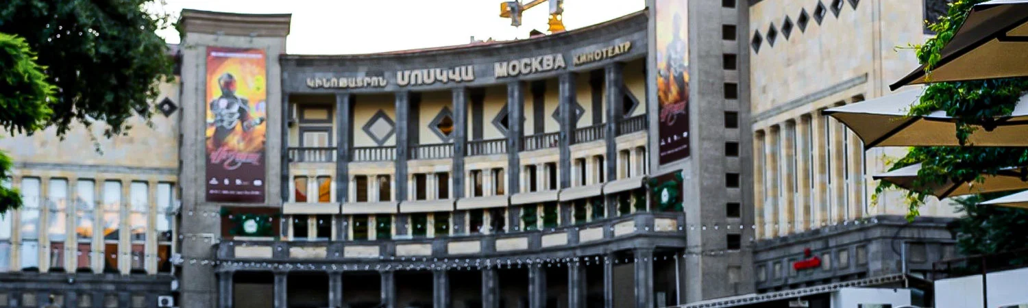 A vibrant view of the iconic Moscow Cinema in Yerevan, Armenia, showcasing its architectural beauty and the lively atmosphere of the surrounding area.