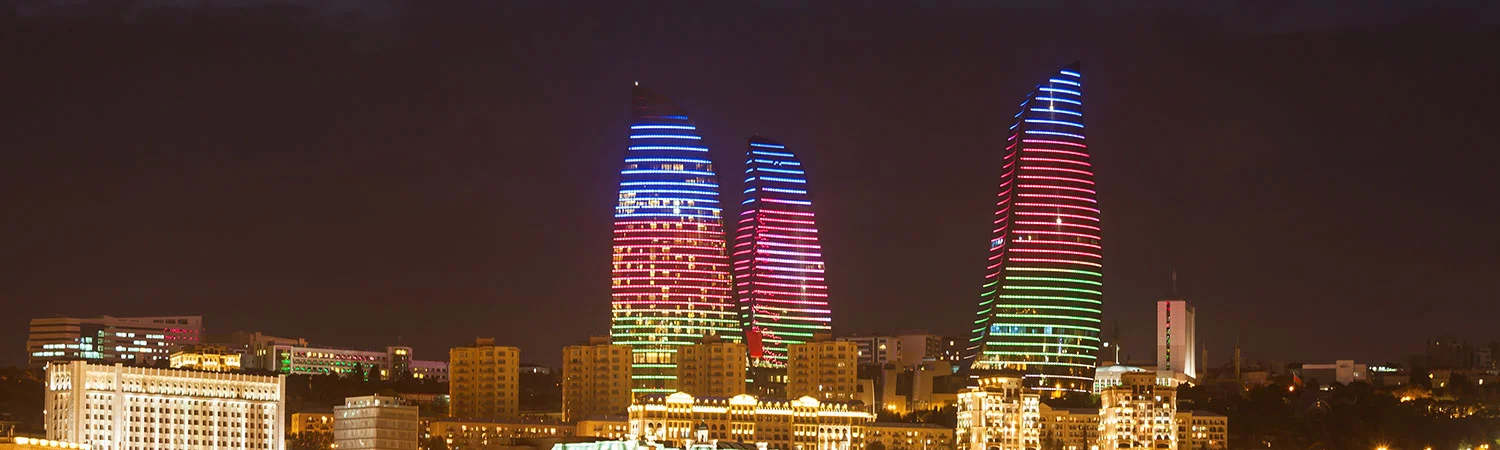 Night view of the iconic Flame Towers illuminated with colorful lights, standing tall against the Baku skyline in Azerbaijan