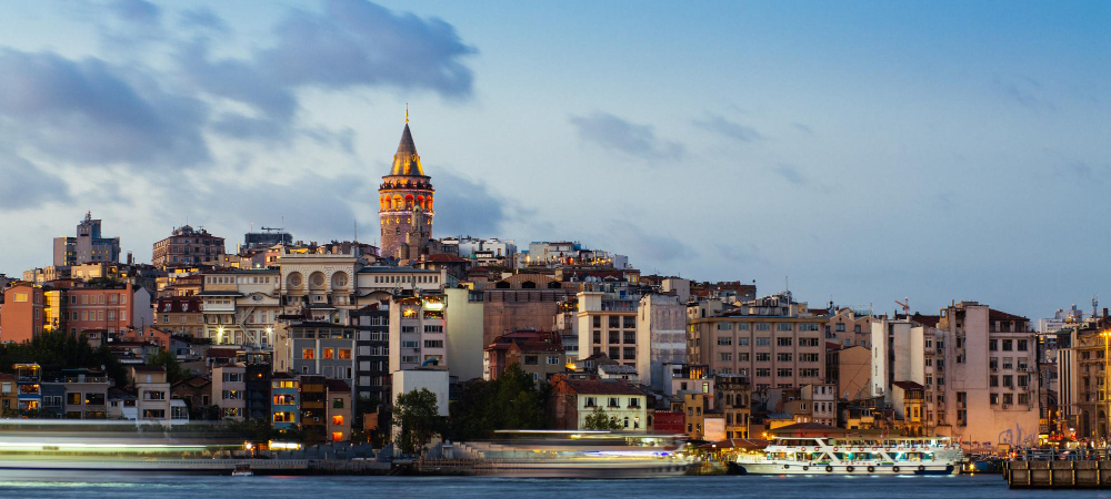 Istanbul cityscape with Galata Tower and floating tourist boats in Bosporus